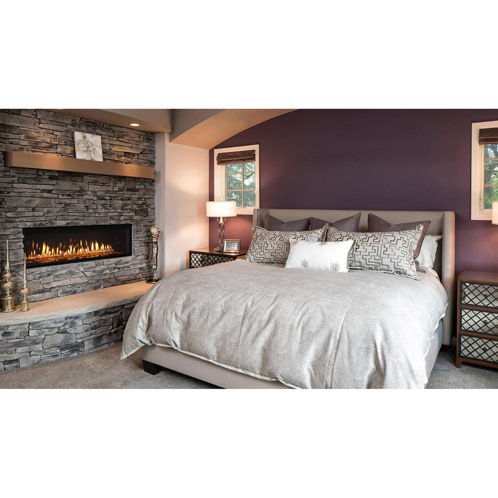 Heat & Glo Mezzo AU linear modern indoor gas fireplace with ribbon flame and amber glass on stone wall in master bedroom. — official Mezzo Linear Indoor Gas Fireplace series image; may show a different size and separately selected options