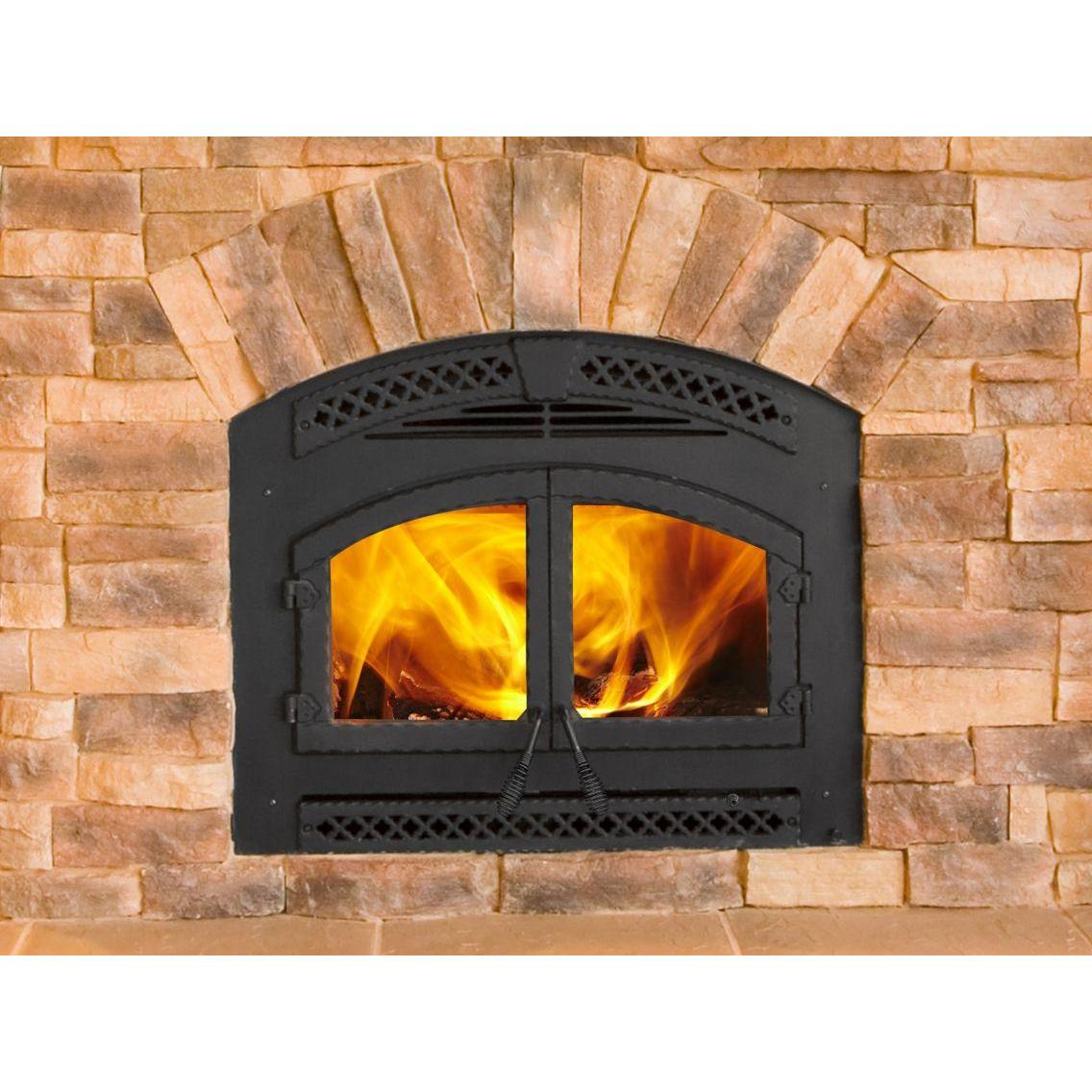 Heat & Glo Northstar wood-burning fireplace in log cabin living room with brick hearth wall with doors closed and fire.. Official series illustration; size and optional finishing may differ from this model.