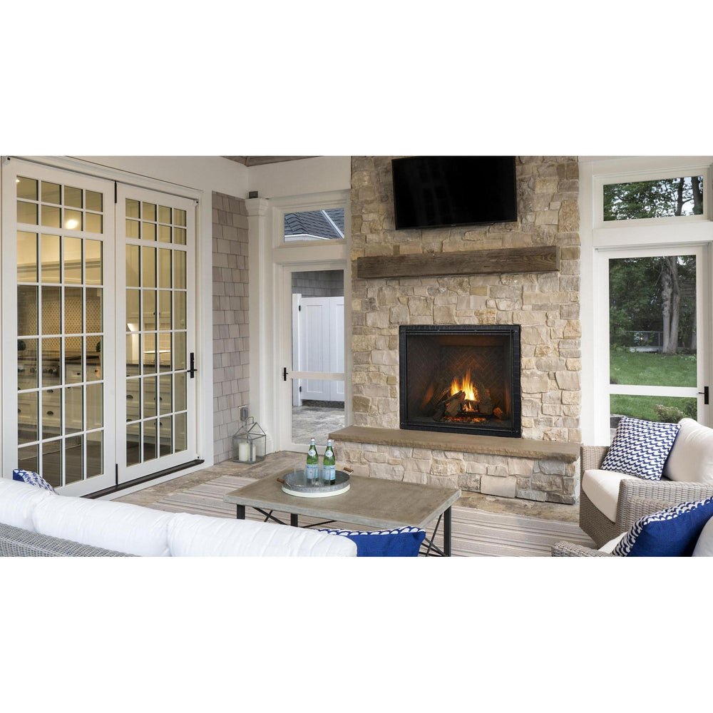 Alt: Heat & Glo True indoor gas fireplace with bold flame and Herringbone brick on stone wall in living room with TV above. — official True Indoor Gas Fireplace series image; may show a different size and separately selected options
